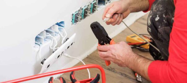 Internet és hálózati aljzatok szakszerű szerelése egy teljes körű ingatlanfelújítás során, ahol a lakásfelújítás kivitelező speciális krimpelő fogóval rögzíti az UTP kábel csatlakozóit a falialjzatba.